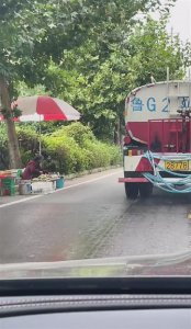 ​精准避让！洒水车工作收放自如，摊主路边淡定摆货